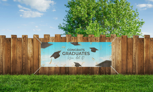 Teal mesh grduation banner on wooden fence