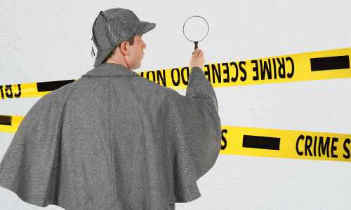 investigator using a magnifying class to look at a wall with crime scene tape